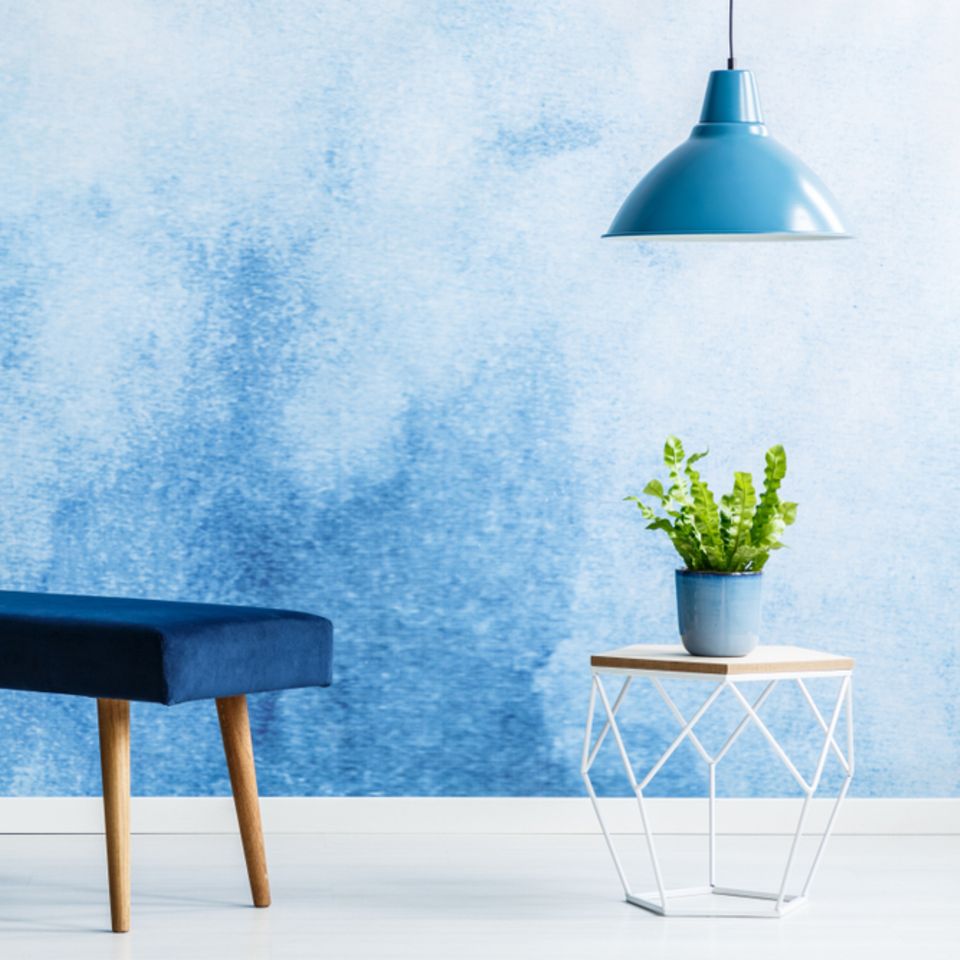 Wand streichen Ideen: Blaue Wand davor Sitzbank, Tisch und Lampe