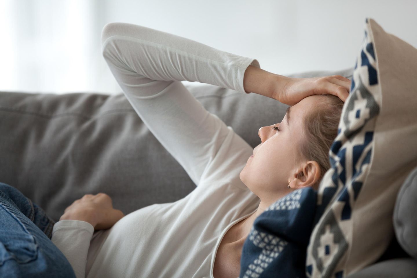 Spannungskopfschmerzen: Frau liegt auf dem Sofa
