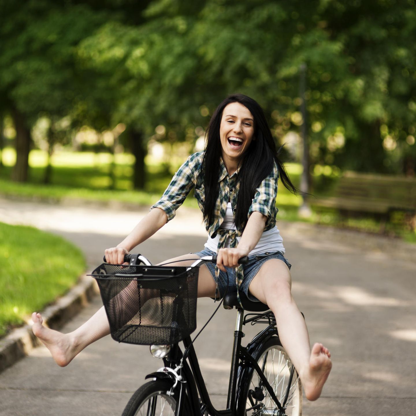 Gute-Laune-Fakten: Eine fröhliche junge Frau auf dem Fahrrad