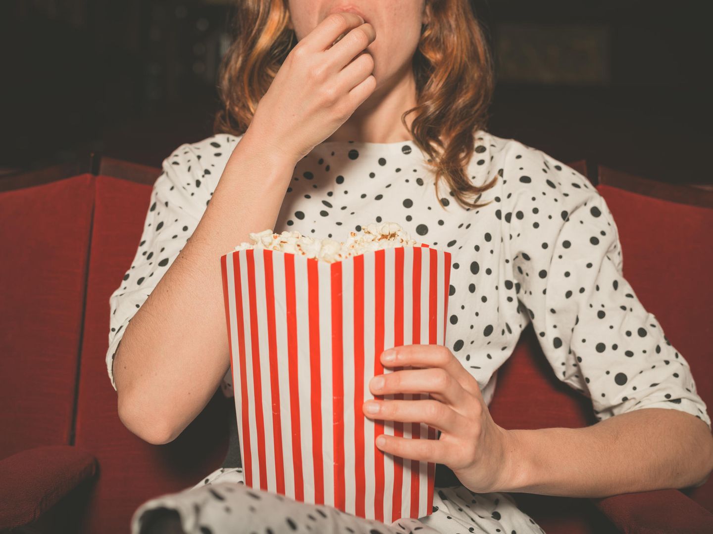 Liebeskummertipps der Redaktion: Eine Frau im Kino mit Popcorn in der Hand