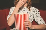 Liebeskummertipps der Redaktion: Eine Frau im Kino mit Popcorn in der Hand