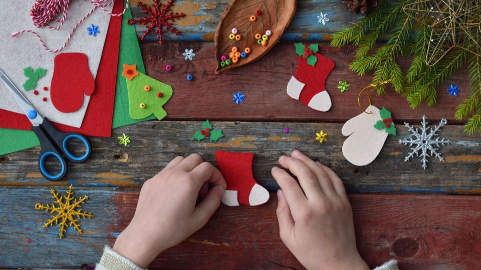 Weihnachtsbasteln mit Kindern: Kinderhände basteln mit Bastelkarton