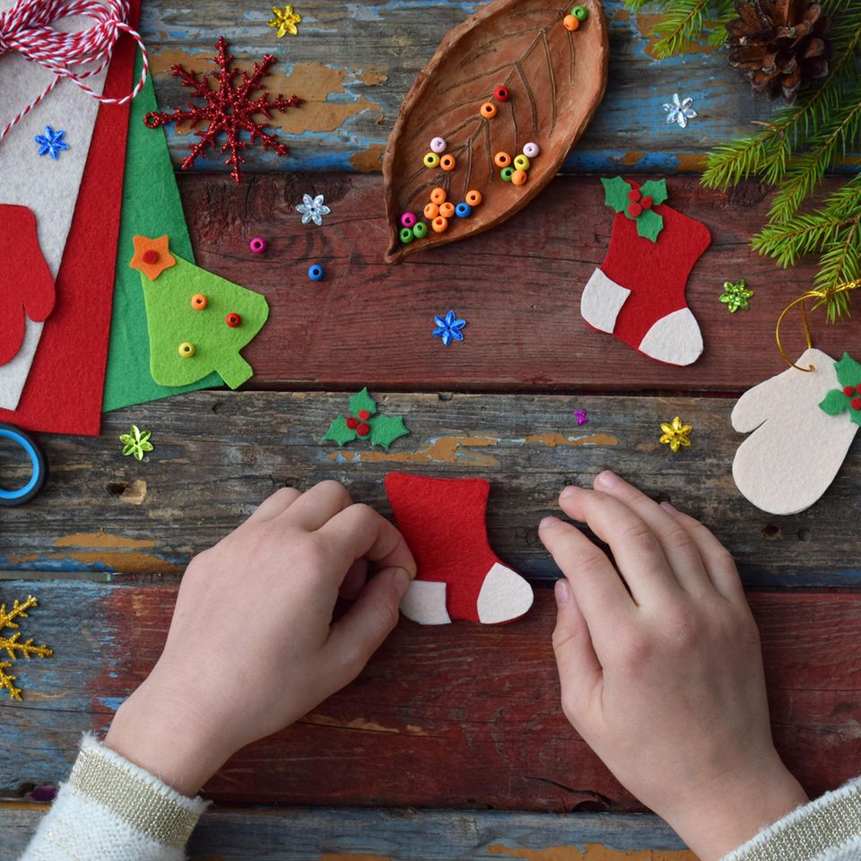 Weihnachtsbasteln mit Kindern: Kinderhände basteln mit Bastelkarton