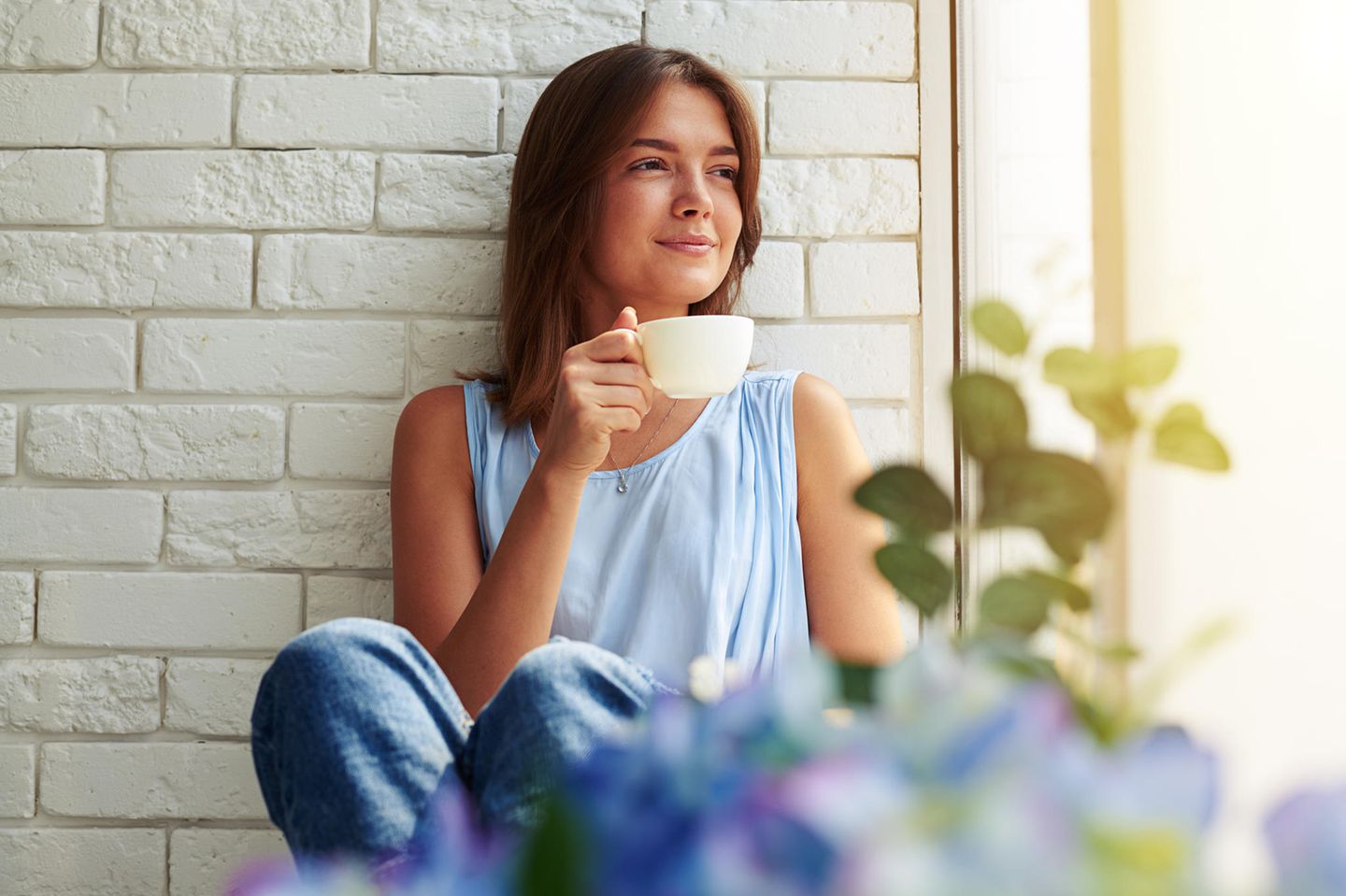 Eisenhower-Prinzip: Eine junge Frau sitzt auf der Fensterbank und trinkt einen Tee
