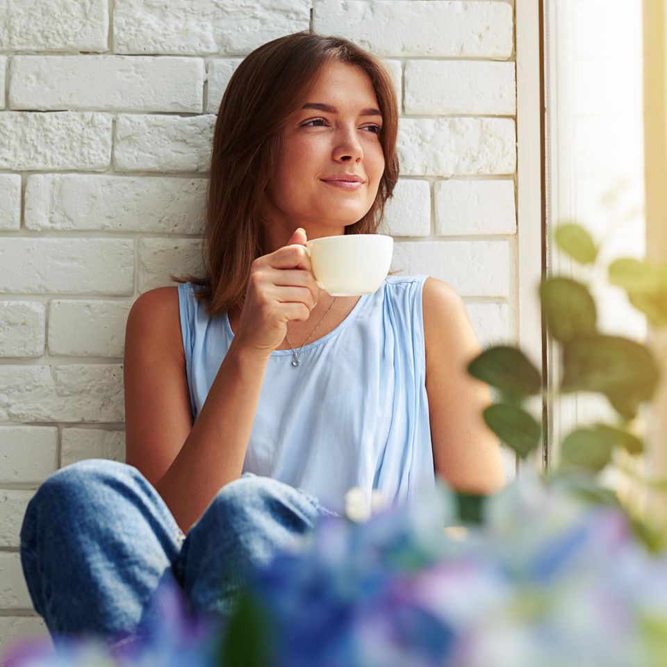 Eisenhower-Prinzip: Eine junge Frau sitzt auf der Fensterbank und trinkt einen Tee