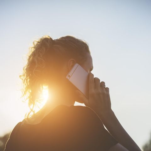 Emotional intelligent: Frau telefoniert im Sonnenuntergang