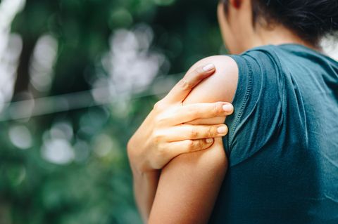 Gliederschmerzen: Frau hält sich den Oberarm