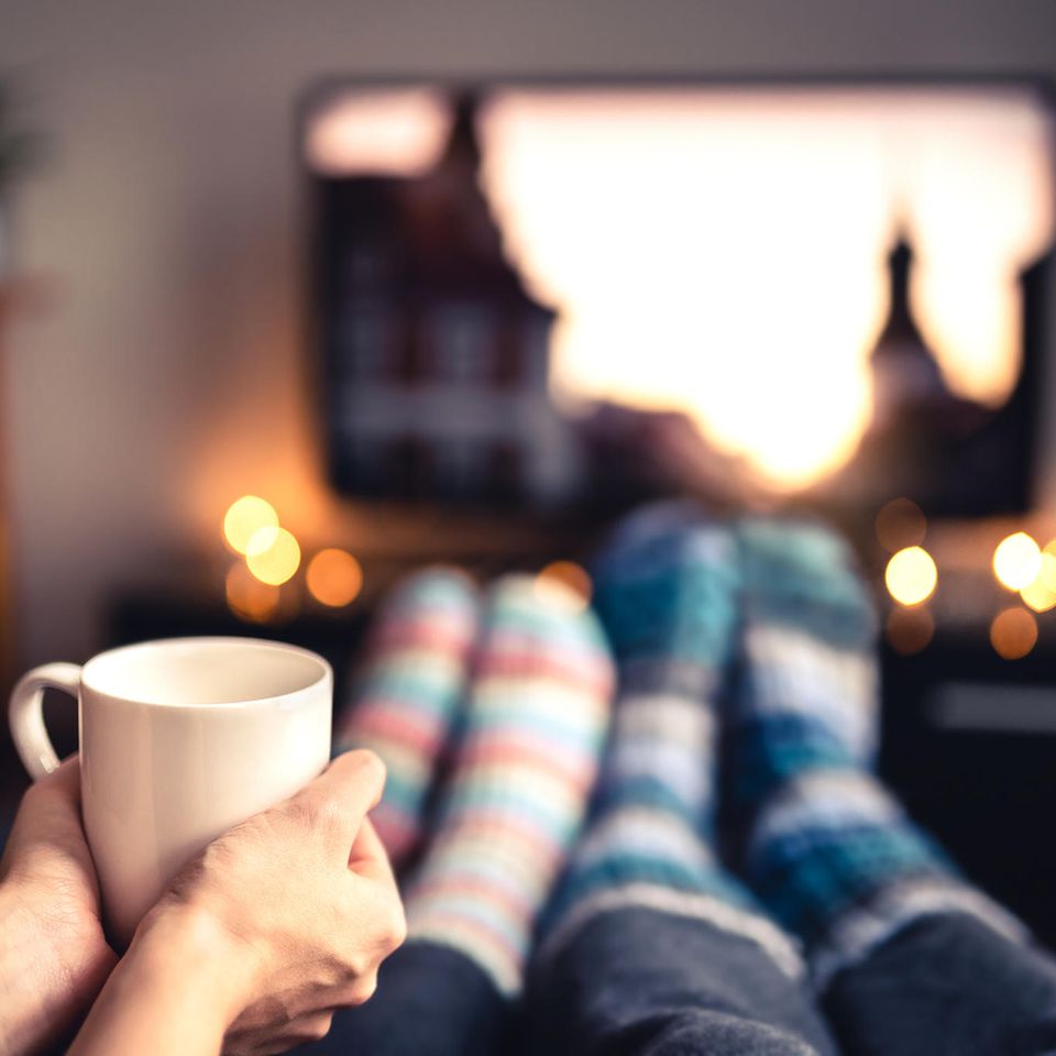 Winterfilme: Paar schaut TV mit Becher in der Hand