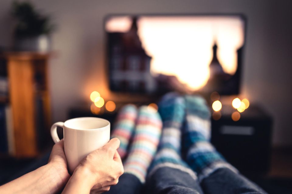 Winterfilme: Paar schaut TV mit Becher in der Hand