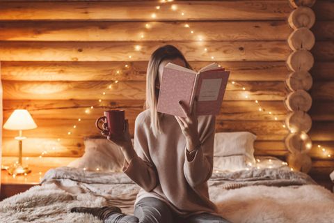 Lieblingsbücher im Winter: Frau liest Buch im Bett