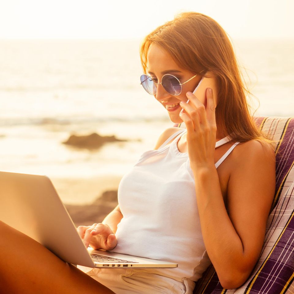 Bewerbung für einen Ferienjob: Frau arbeitet am Strand am PC