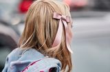 Weihnachtsfrisuren: Mädchen mit rosa Schleife im Haar