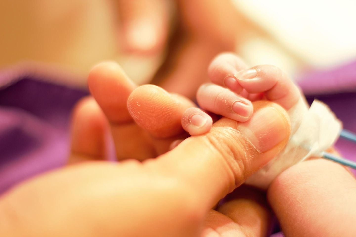 Fetus in fetu: Symbolbild Mutter Baby halten Händchen