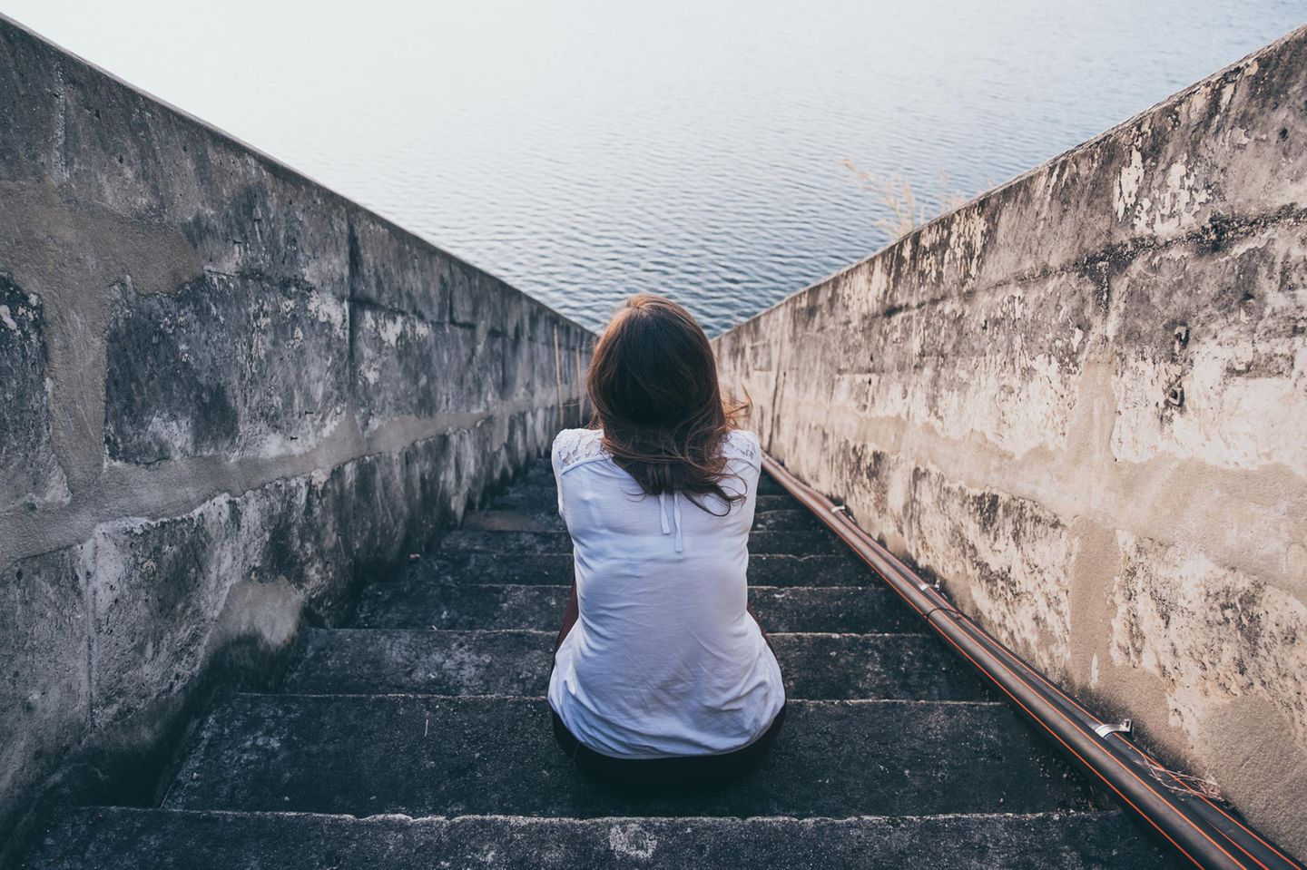 Angst: Frau sitzt auf einer Treppe