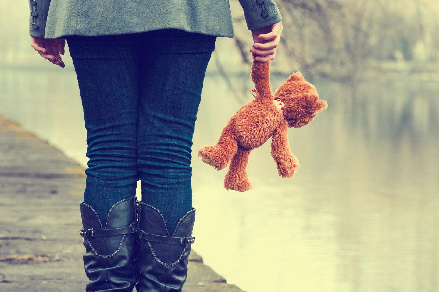 Frau mit Teddy auf Steg