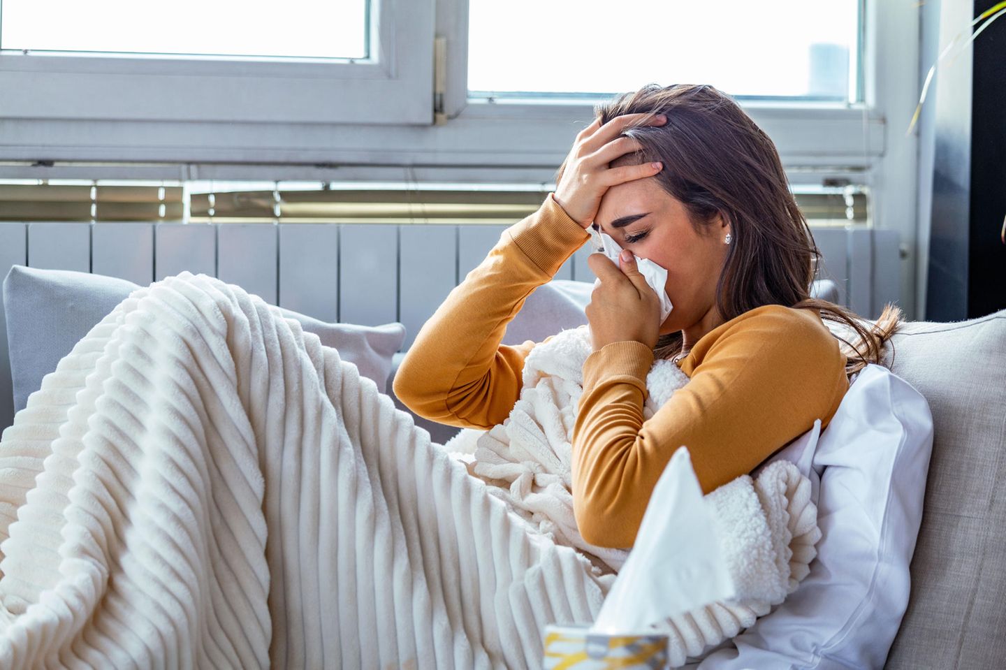Verlauf einer Erkältung: Drei Phasen der Krankheit: Kranke Frau im Bett