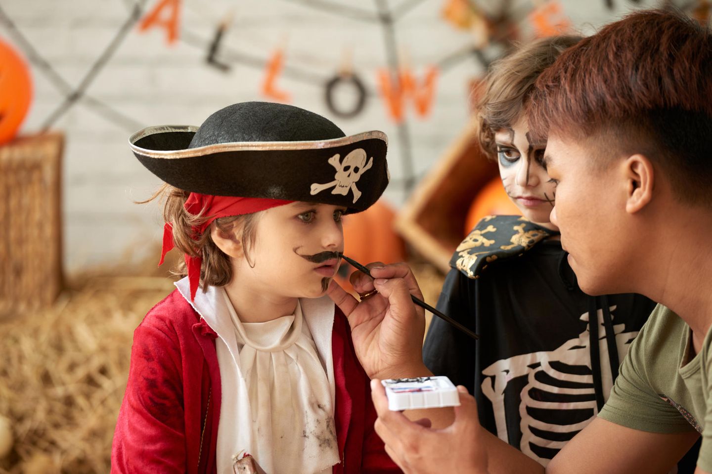 Als Pirat schminken: Junge wird als Pirat geschminkt