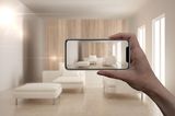 Smart Living: Wohnzimmer durch Smartphone-Bildschirm sichtbar