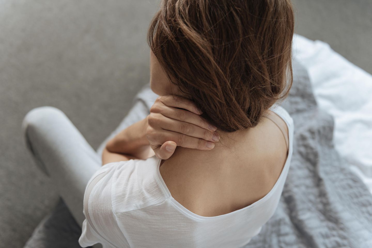 Nackenschmerzen: Frau hält sich den Nacken
