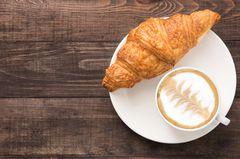 Kalorien im Frühstück: Croissant Croissant und Milchkaffee auf Teller
