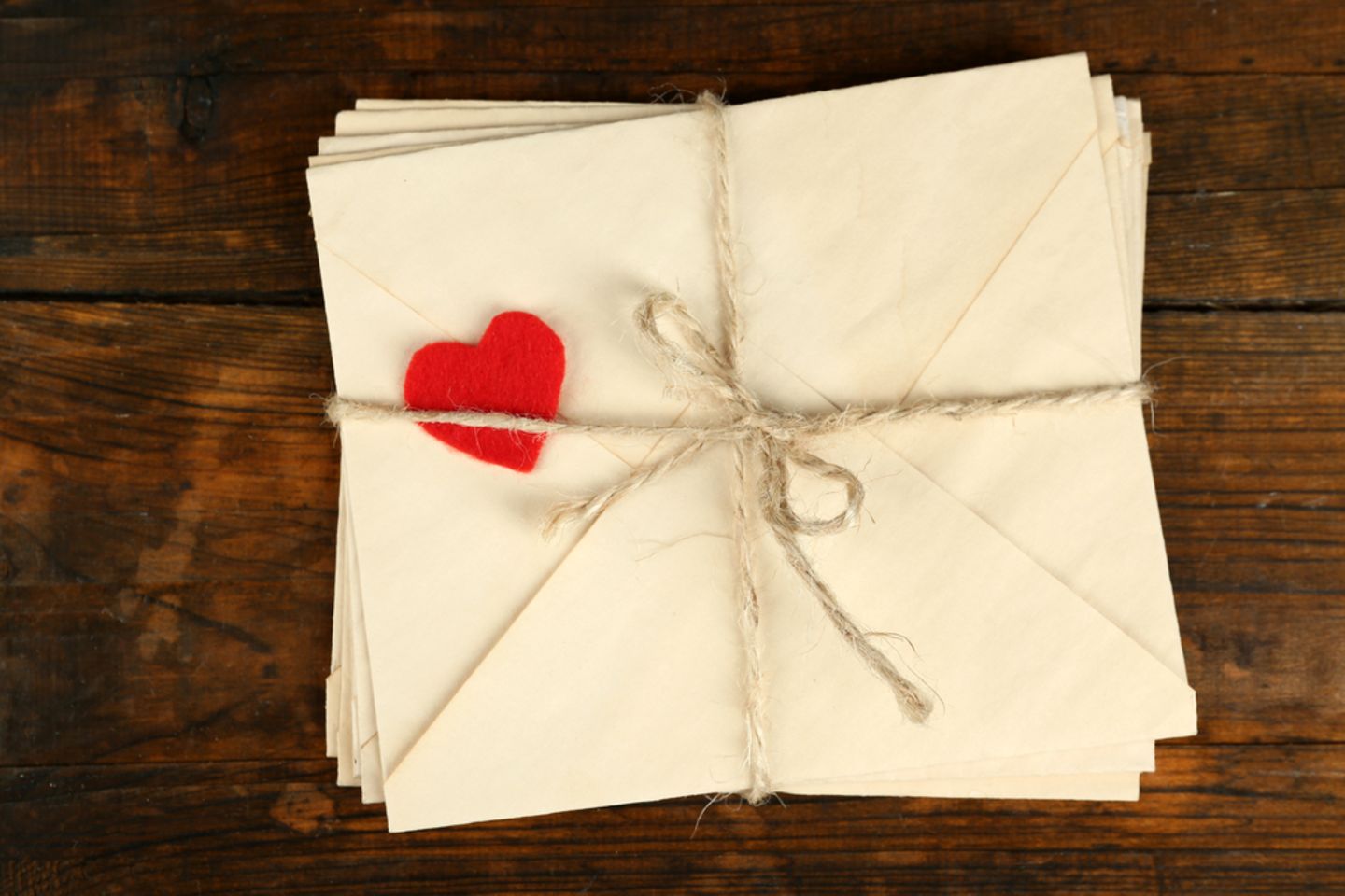 Liebesbrief schreiben: Briefstapel und ein Dekoherz