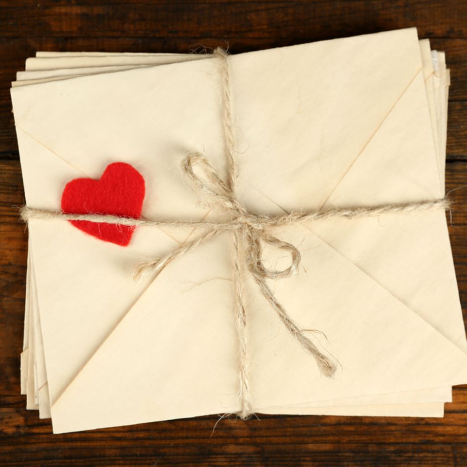 Liebesbrief schreiben: Briefstapel und ein Dekoherz
