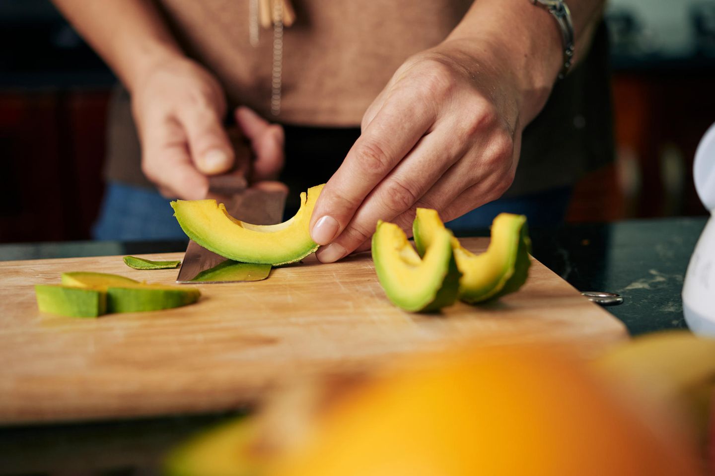 Koch schneidet Avocado in Scheiben