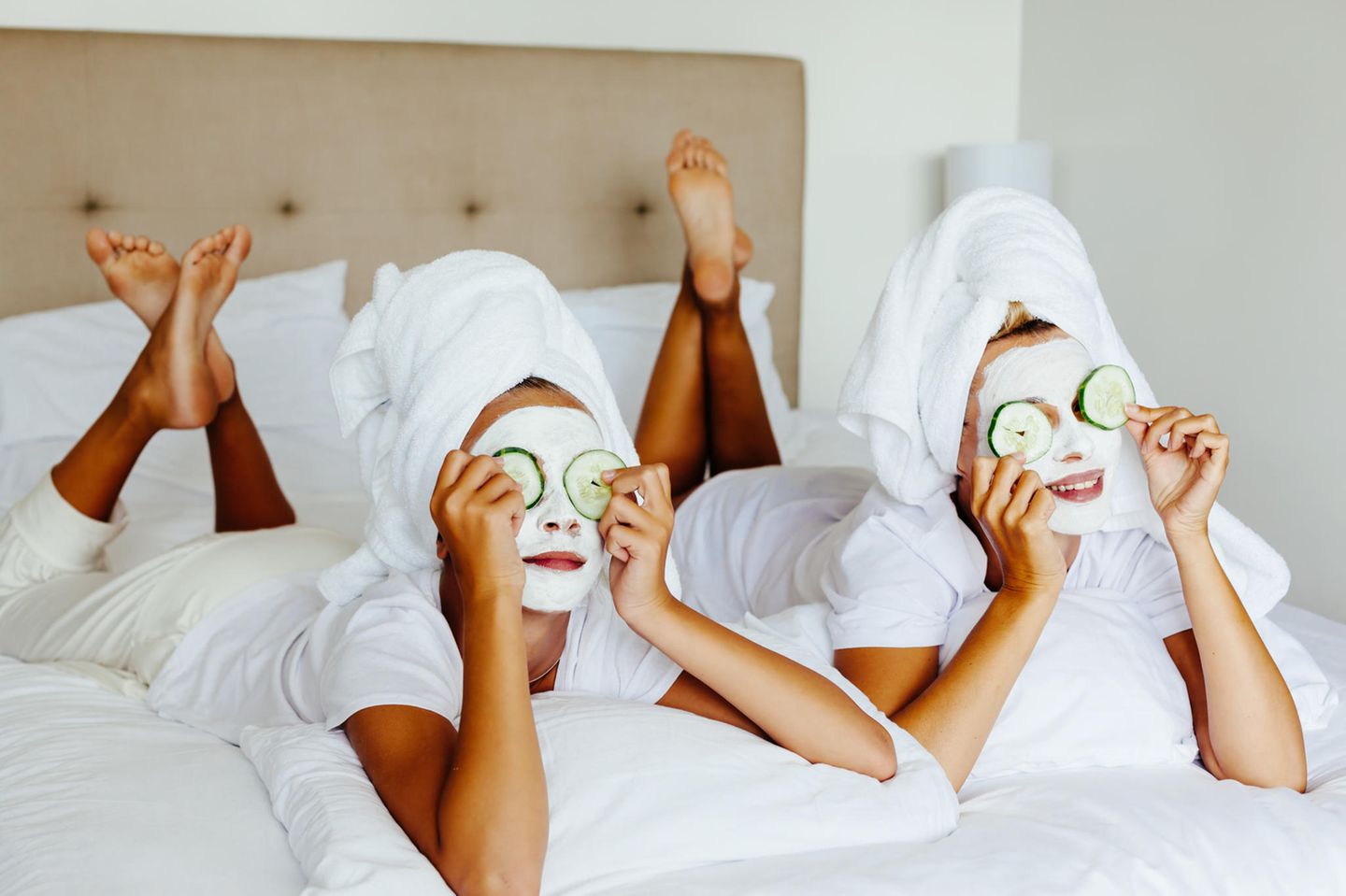 Neujahrs-Skin-Detox: zwei Frauen mit Gesichtsmasken und Gurkenscheiben auf den Augen