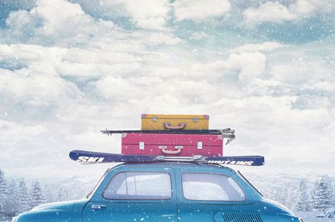 Packliste für den Skiurlaub: Auto mit Koffern und Skiern auf dem Dach