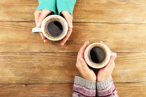 Deshalb solltest du morgens auf den Kaffee verzichten: Frauen halten Kaffeetasse fest