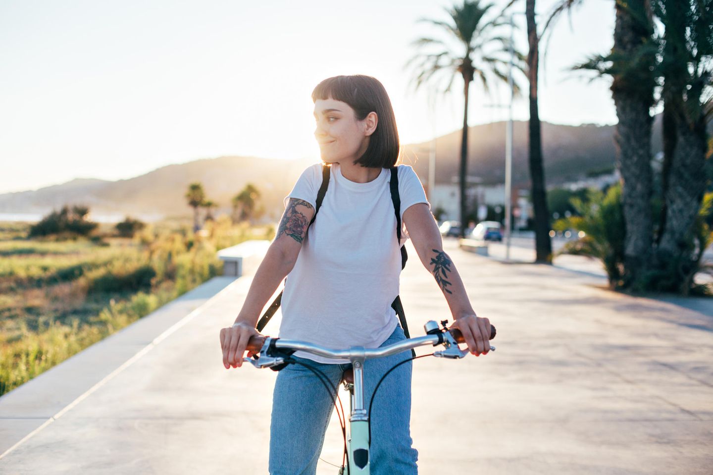 Selbstoptimierung: Eine zufriedene junge Frau auf dem Fahrrad