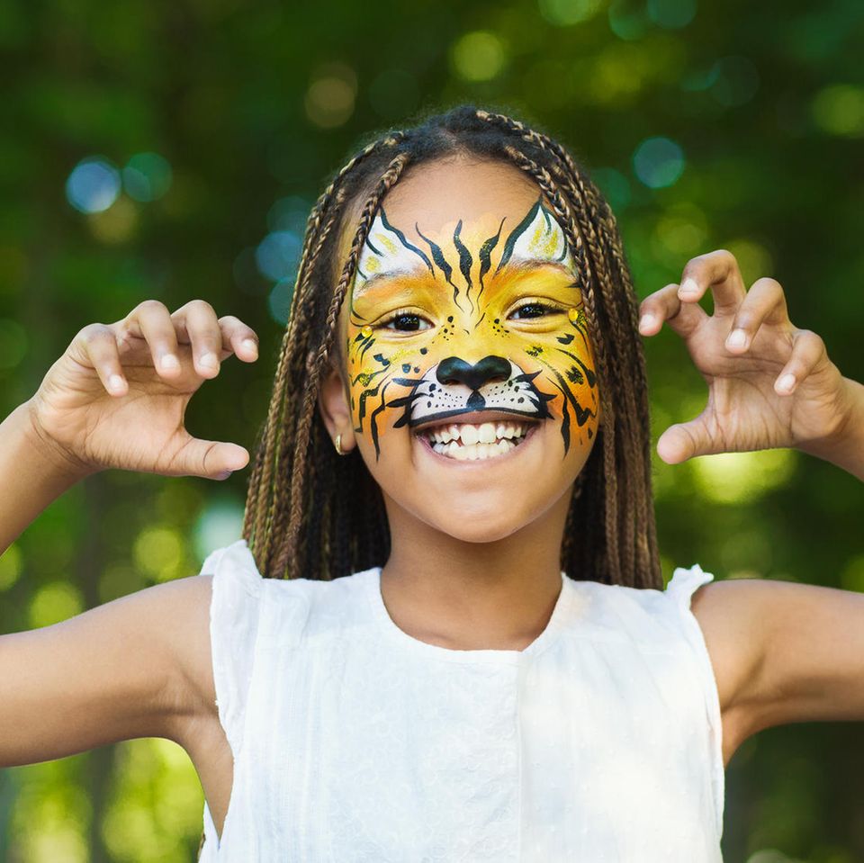 Tiger schminken: Mädchen mit geschminktem Tiger-Gesicht