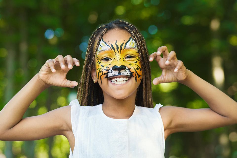 Tiger schminken: Mädchen mit geschminktem Tiger-Gesicht