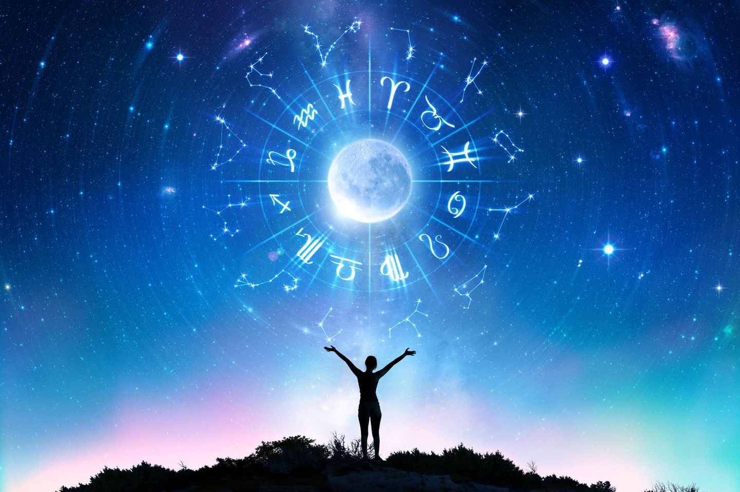 Horoskop: Ein Mensch streckt die Hände in den Himmel, in dem die Sternzeichen abgebildet sind