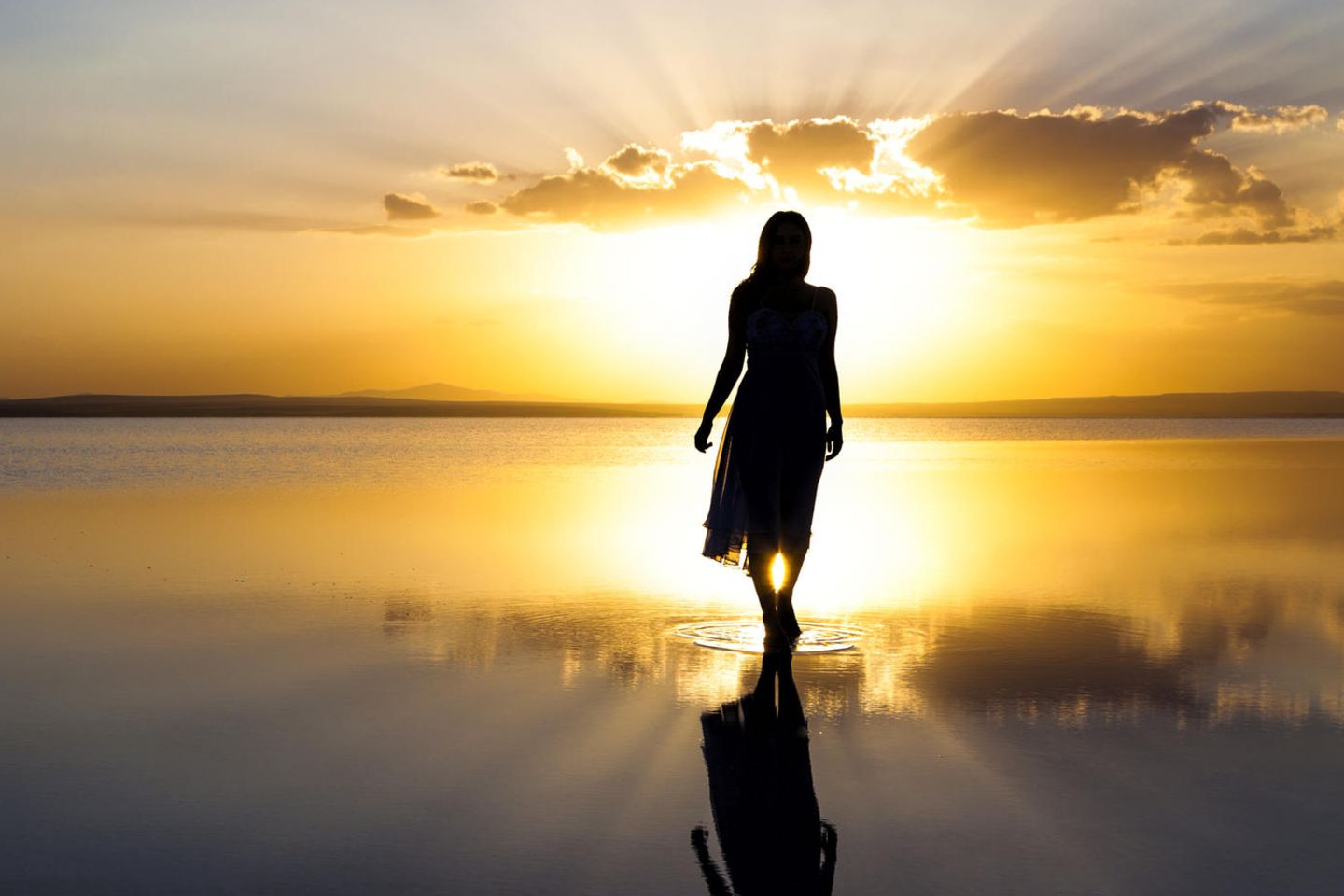 Horoskop: Eine Frau am Meer bei Sonnenaufgang