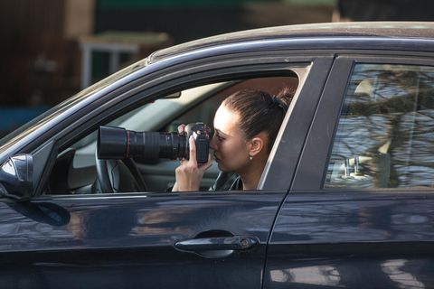 Detektiv: Detektivin sitzt in ihrem Auto und macht heimlich Fotos