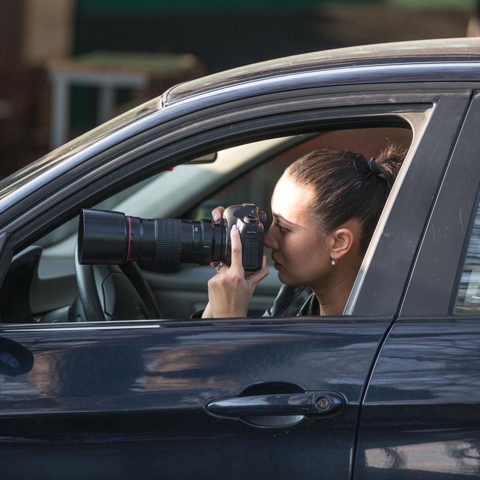 Detektiv: Detektivin sitzt in ihrem Auto und macht heimlich Fotos