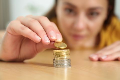 Sparen mit kleinen Beträgen: "3 Euro? Das lohnt sich!": Frau stapelt Münzgeld