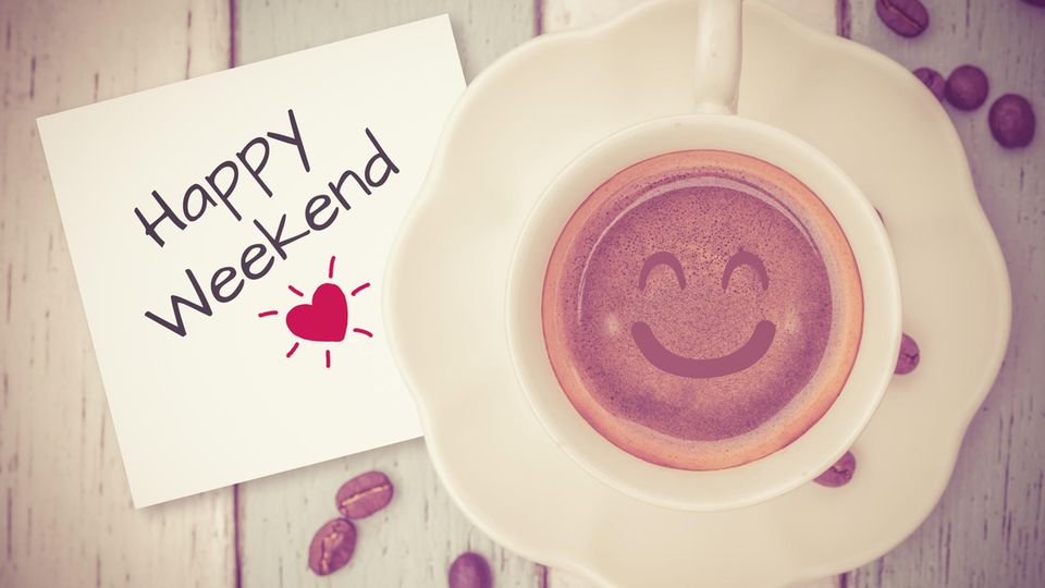 Horoskop: Ein Schild mit der Aufschrift Happy Weekend und eine Tasse mit lächelndem Kaffee