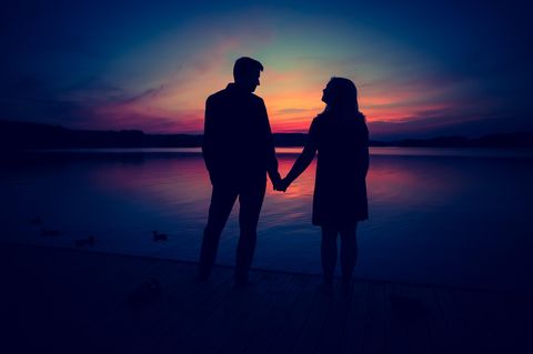 Paar hält Händchen vor Sonnenuntergang