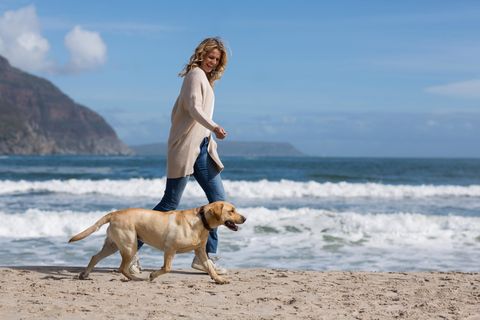 Wechseljahresbeschwerden lindern: Das hat geholfen: Frau mit Hund am Strand