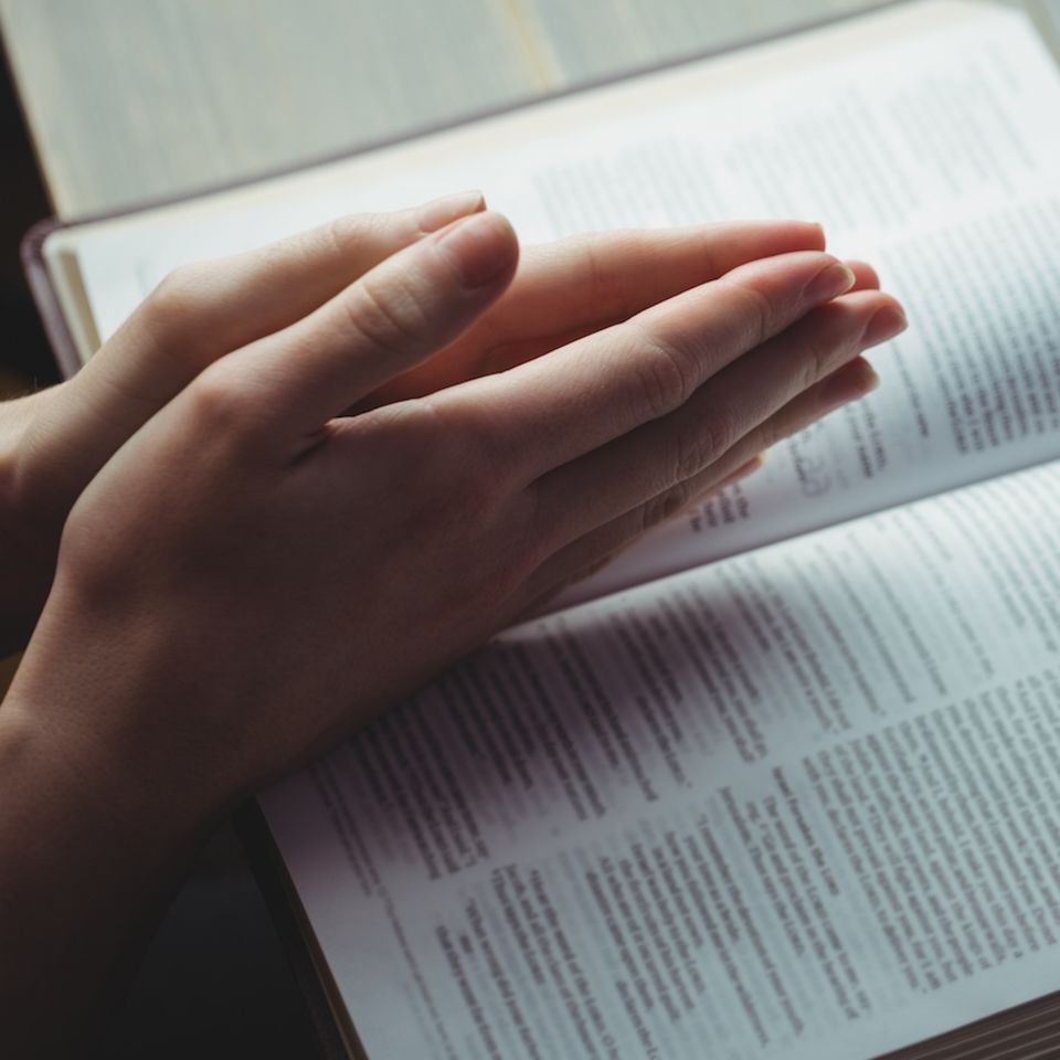 Jehovas Zeuge: Betende Hände über einem Buch