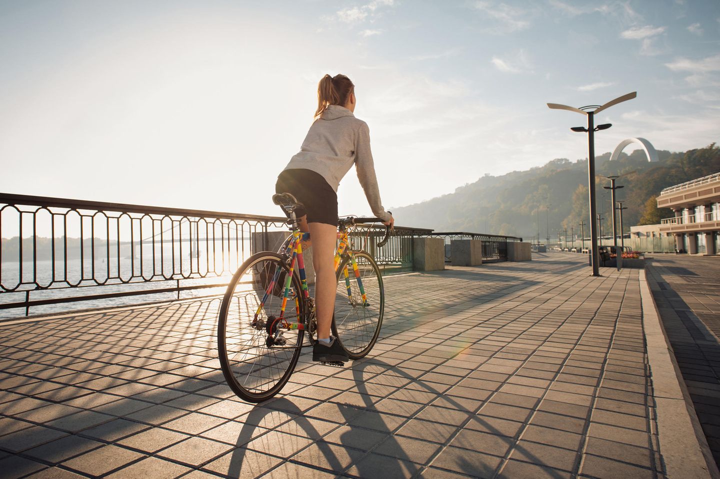 Frau mit Rennrad auf Promenade