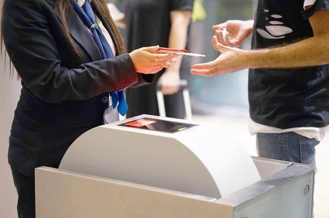 Frau kontrolliert Pass am Flughafen