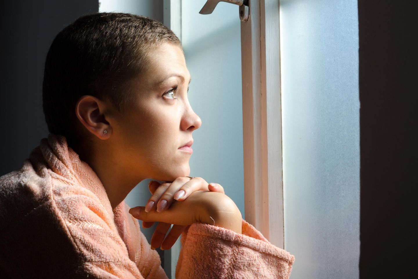 Krebserkrankungen: Krebskranke Frau am Fenster