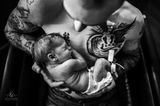 Geburtsfotos 2020: Mann hält Neugeborenes im Arm