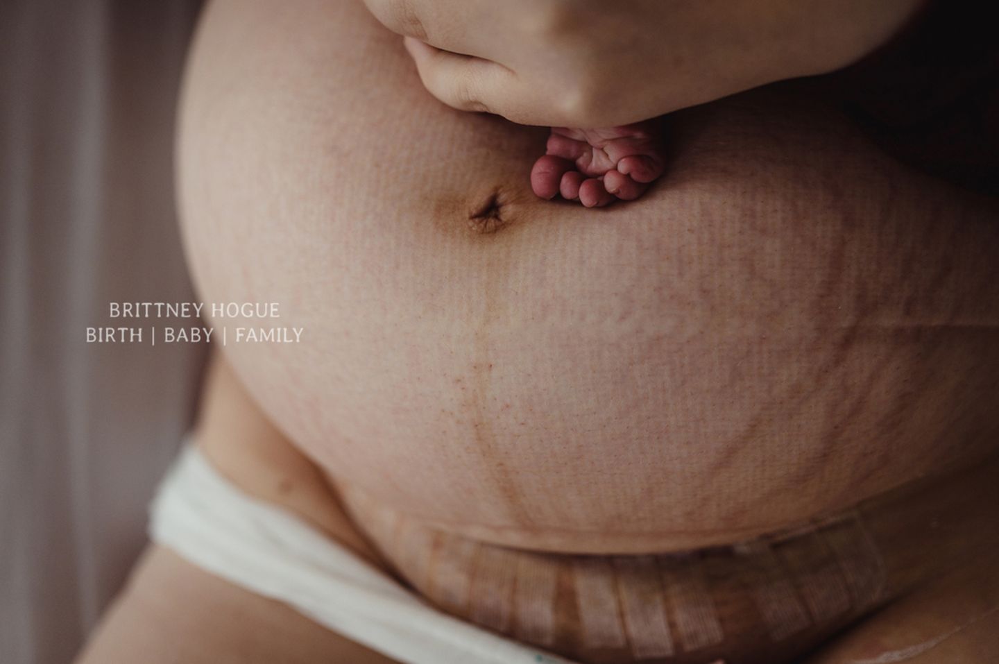 Geburtsfotos 2020: Mutterbauch mit Babyfuss
