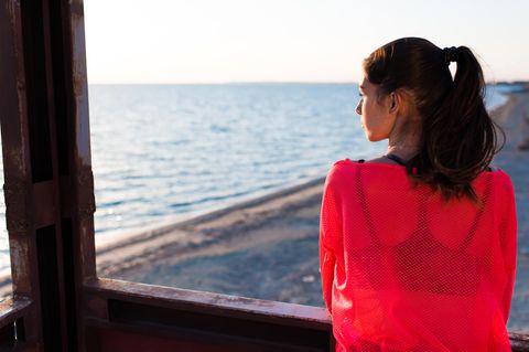 Horoskop: Eine nachdenkliche, traurige Frau schaut aufs Meer