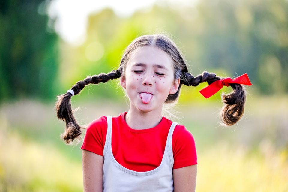 Pippi Langstrumpf Sprüche: Mädchen mit Zöpfen streckt die Zunge heraus