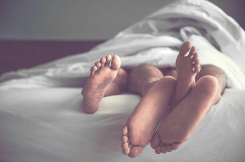 Füße von Paar im Bett